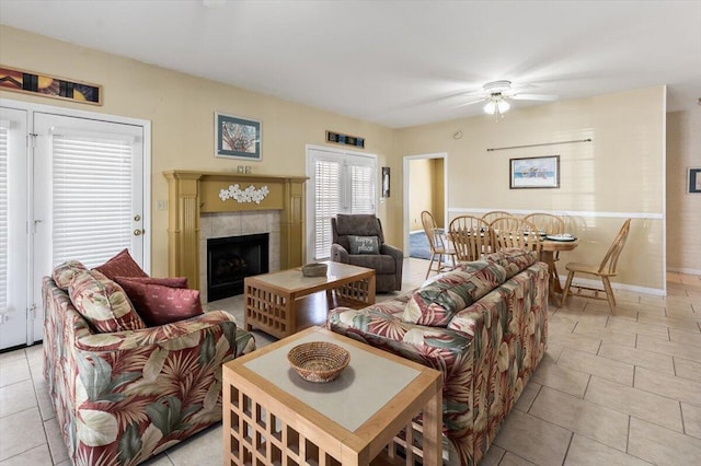 tiled living room featuring ceiling fan and a fireplace