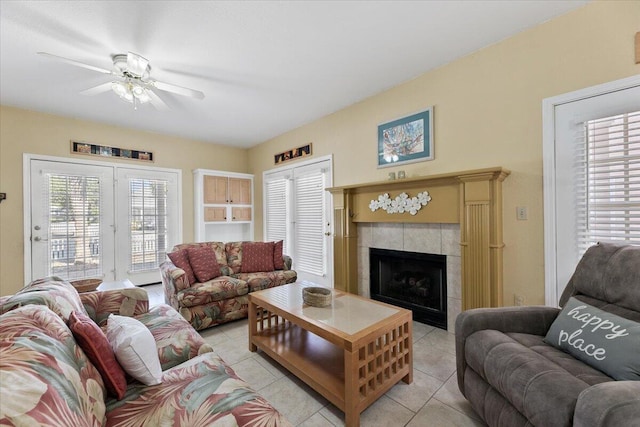 tiled living room featuring a fireplace and ceiling fan