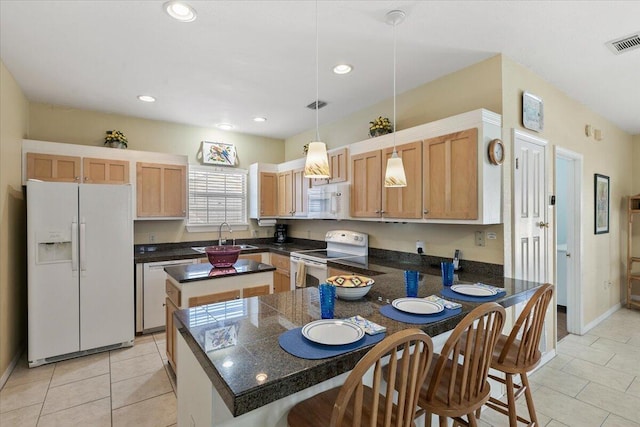 kitchen featuring decorative light fixtures, light tile patterned floors, sink, white appliances, and a center island