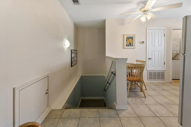 stairway with ceiling fan and tile patterned floors