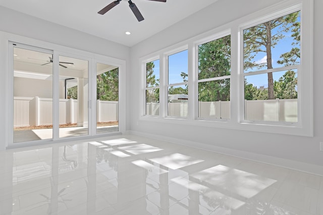 unfurnished sunroom with ceiling fan