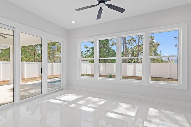 unfurnished sunroom featuring ceiling fan