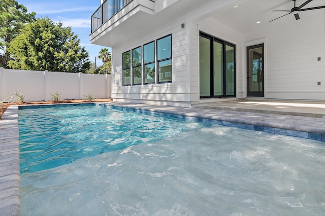 view of swimming pool featuring ceiling fan and a patio