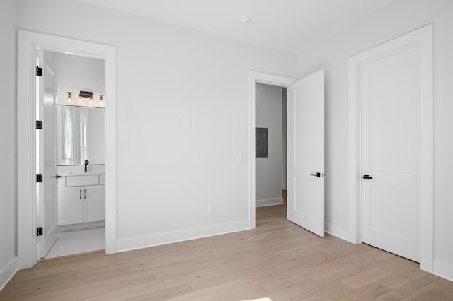 unfurnished bedroom featuring connected bathroom and light hardwood / wood-style flooring