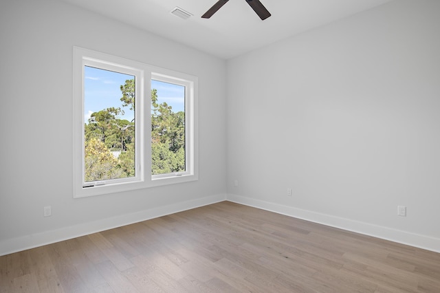 empty room with light hardwood / wood-style flooring, a healthy amount of sunlight, and ceiling fan