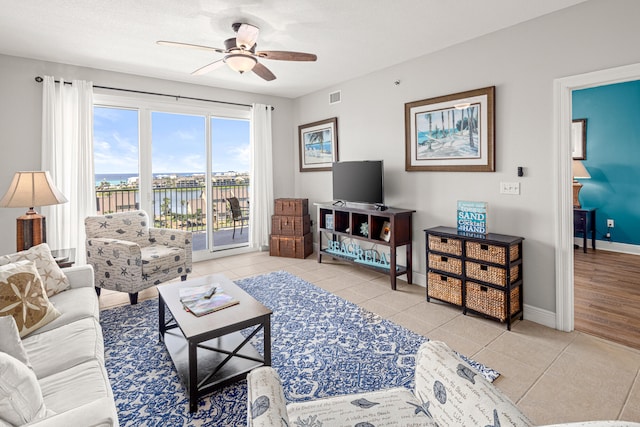 tiled living room with ceiling fan