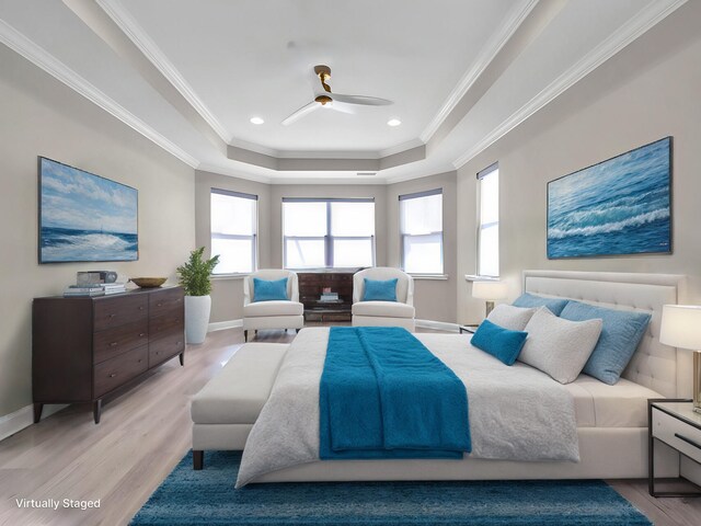 bedroom featuring light hardwood / wood-style floors, ceiling fan, a tray ceiling, and ornamental molding