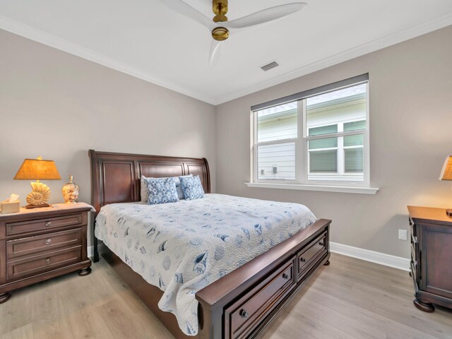 bedroom featuring ceiling fan, light wood-type flooring, and ornamental molding