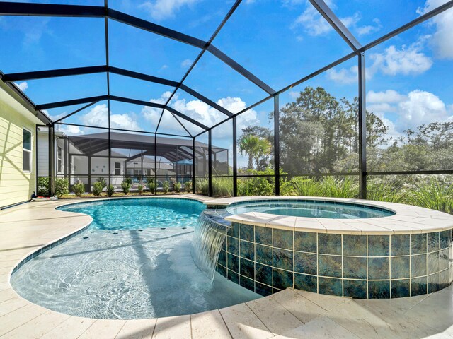 view of pool featuring pool water feature, glass enclosure, a patio, and an in ground hot tub