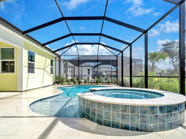 view of pool with a patio, a lanai, and an in ground hot tub