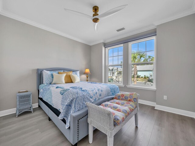 bedroom with light hardwood / wood-style floors, ceiling fan, and crown molding