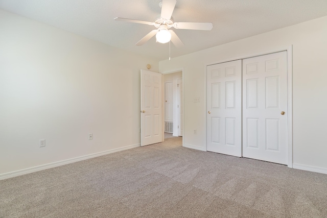 unfurnished bedroom featuring light carpet, a closet, and ceiling fan