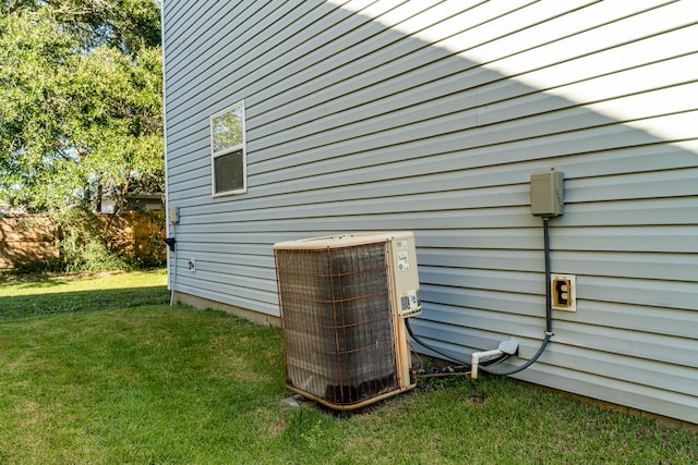 exterior space featuring cooling unit and a lawn