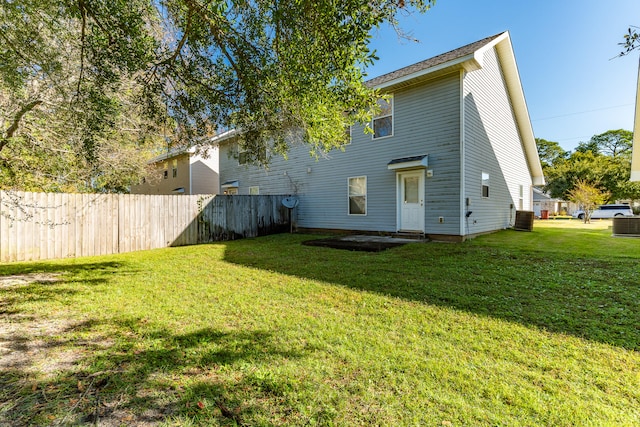 back of property featuring a yard and central air condition unit