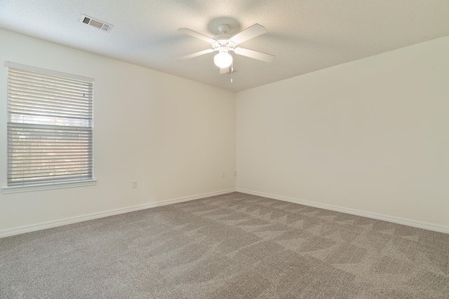 empty room with ceiling fan, carpet, and a textured ceiling