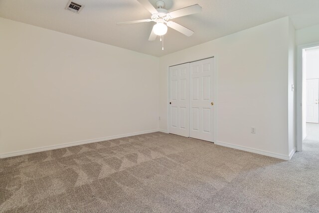 unfurnished bedroom with ceiling fan, light colored carpet, and a closet