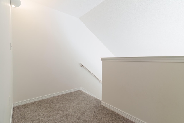 stairs with carpet floors and vaulted ceiling