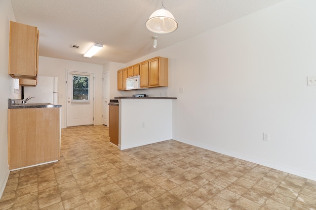 kitchen featuring hanging light fixtures, white appliances, and a textured ceiling