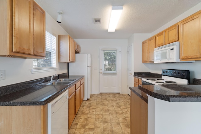 kitchen with sink, white appliances, kitchen peninsula, and a textured ceiling