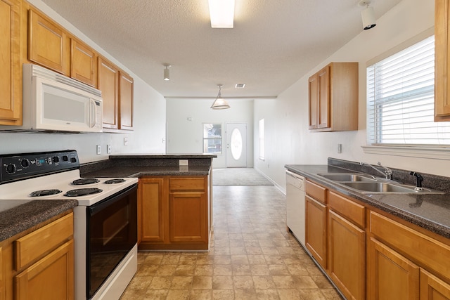 kitchen with sink, white appliances, and hanging light fixtures