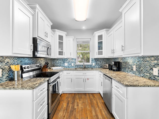 kitchen with white cabinetry, appliances with stainless steel finishes, and dark hardwood / wood-style floors