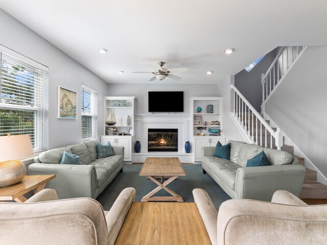 living room with light wood-type flooring and ceiling fan