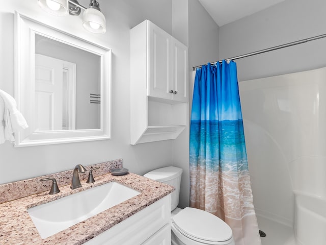 bathroom with toilet, vanity, and a shower with shower curtain