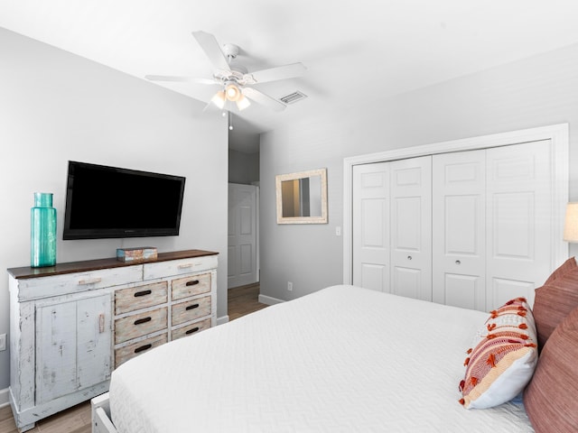 bedroom with hardwood / wood-style floors, ceiling fan, and a closet