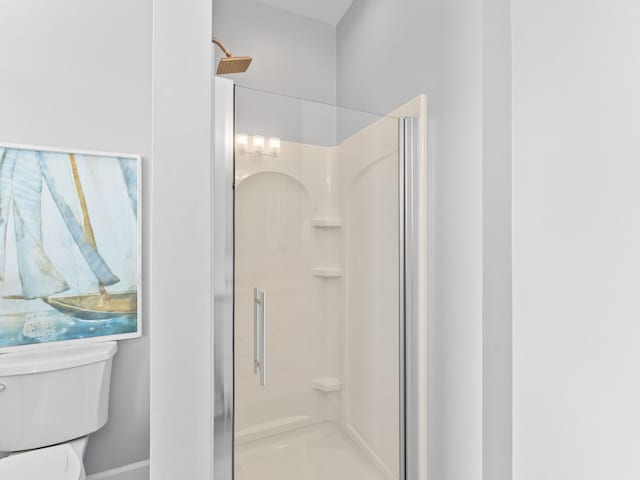 bathroom featuring toilet and an enclosed shower