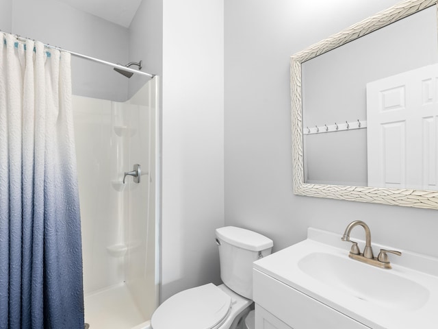 bathroom with toilet, vanity, and a shower with shower curtain