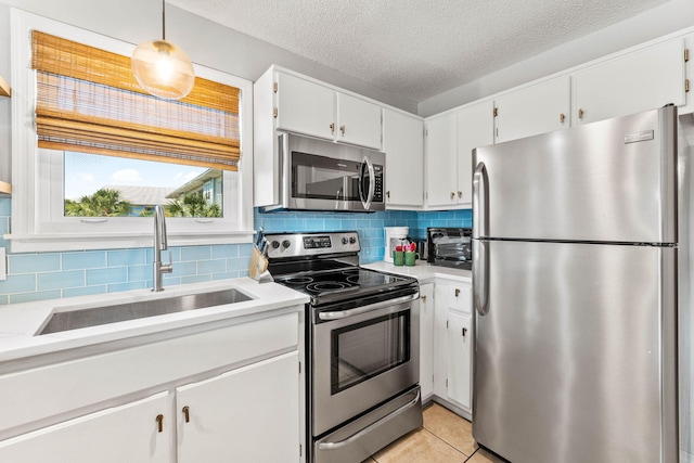 11 Beachside Dr Unit 1121, Santa Rosa Beach, FL 32459 - kitchen featuring appliances with stainless steel finishes, light countertops, decorative backsplash, white cabinetry, and a textured ceiling