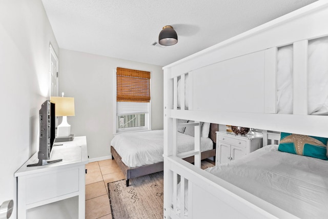 tiled bedroom featuring a textured ceiling