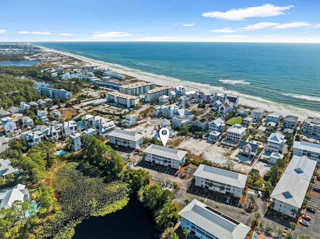 birds eye view of property with a water view and a beach view