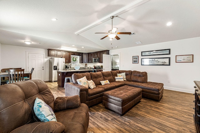 living room featuring dark wood-type flooring, ceiling fan, a textured ceiling, and vaulted ceiling with beams