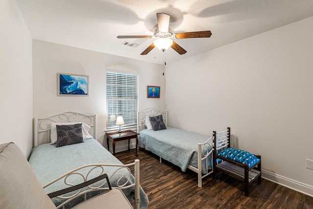 bedroom featuring dark wood-type flooring, a textured ceiling, and ceiling fan