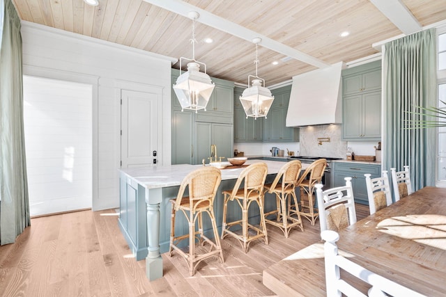 kitchen featuring pendant lighting, custom exhaust hood, light hardwood / wood-style floors, and wooden ceiling