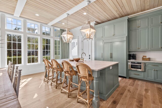 kitchen featuring decorative light fixtures, plenty of natural light, light hardwood / wood-style floors, and wood ceiling