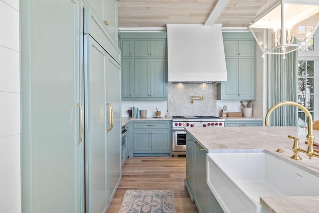 kitchen featuring sink, wooden ceiling, premium range hood, light hardwood / wood-style floors, and range with two ovens