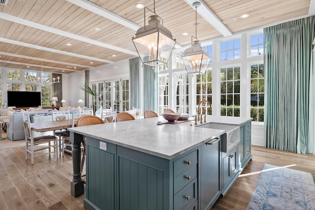 kitchen featuring a center island with sink, wood ceiling, decorative light fixtures, and light hardwood / wood-style floors