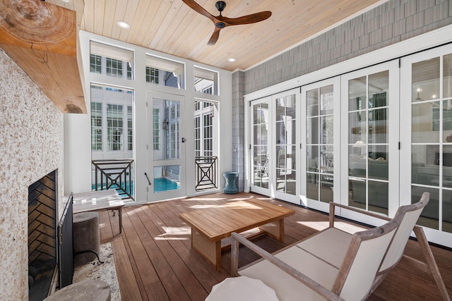 sunroom / solarium with a wealth of natural light, french doors, ceiling fan, and wooden ceiling