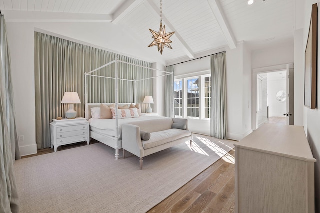 bedroom featuring hardwood / wood-style flooring, lofted ceiling with beams, and a chandelier