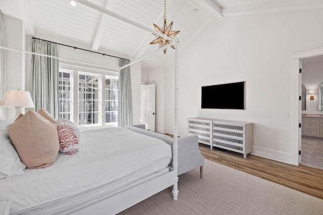 bedroom featuring ensuite bath, beamed ceiling, high vaulted ceiling, and hardwood / wood-style flooring