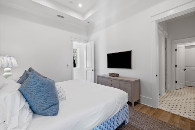 bedroom with light hardwood / wood-style floors and ornamental molding