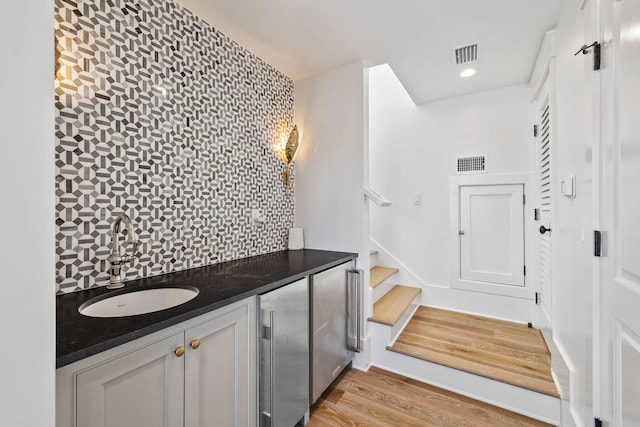 interior space with hardwood / wood-style flooring, decorative backsplash, and vanity