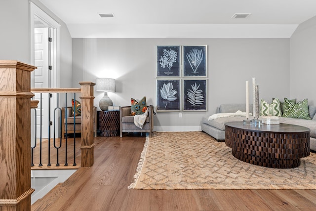 sitting room with wood-type flooring and lofted ceiling