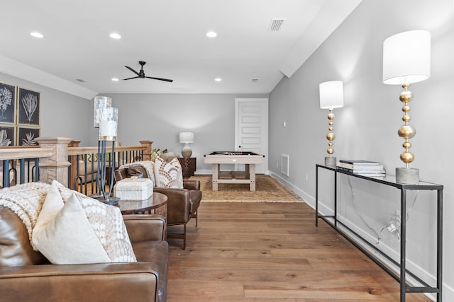 living room featuring wood-type flooring and ceiling fan