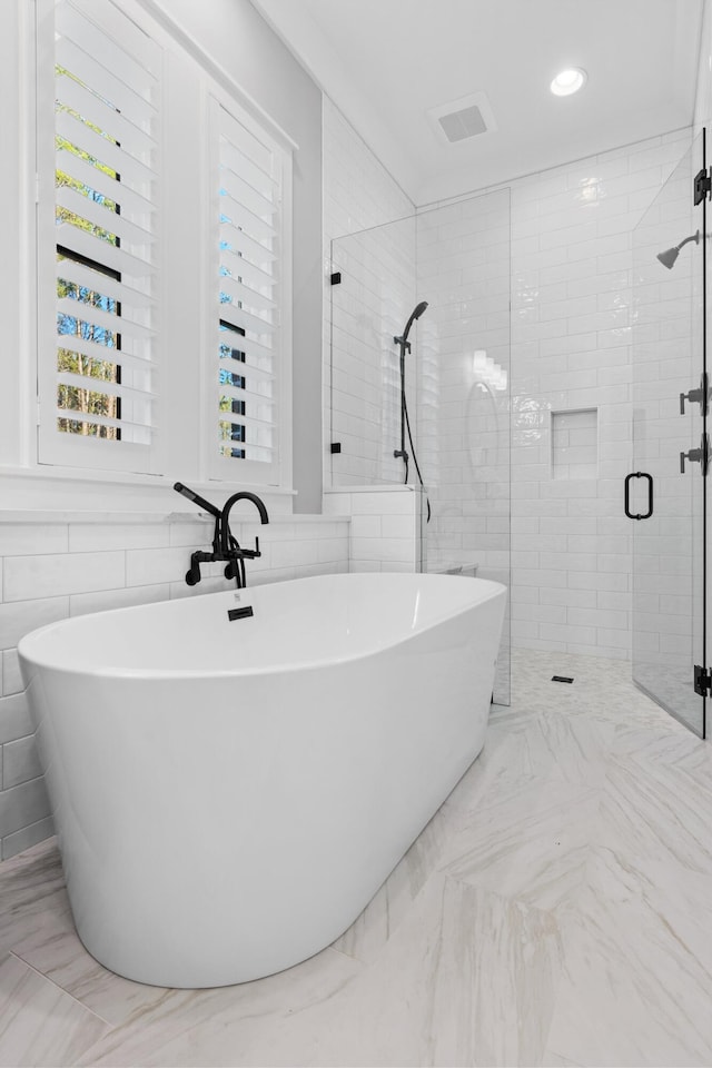 bathroom with separate shower and tub and tile walls