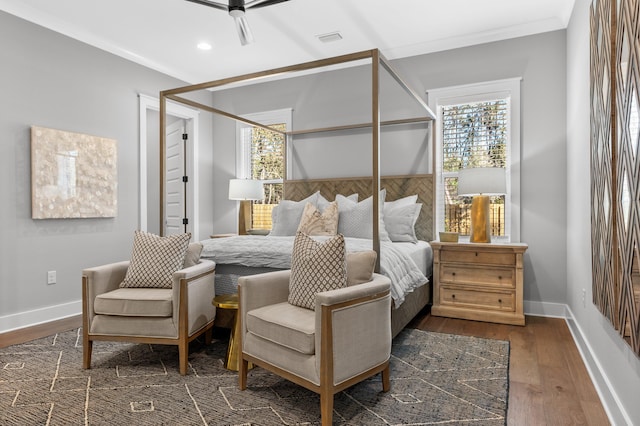 bedroom featuring ceiling fan, multiple windows, dark hardwood / wood-style flooring, and crown molding