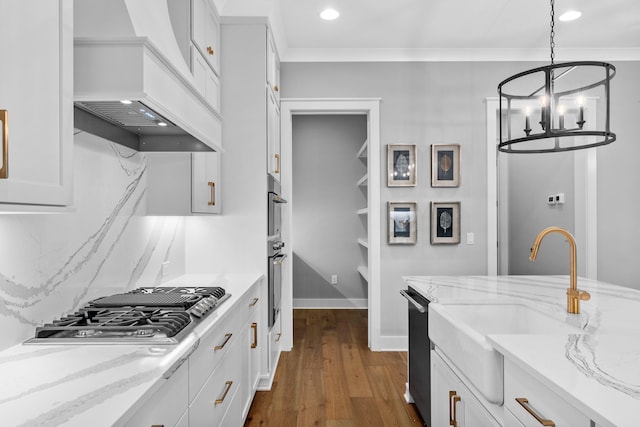 kitchen featuring light stone counters, decorative light fixtures, white cabinets, dark wood-type flooring, and custom exhaust hood