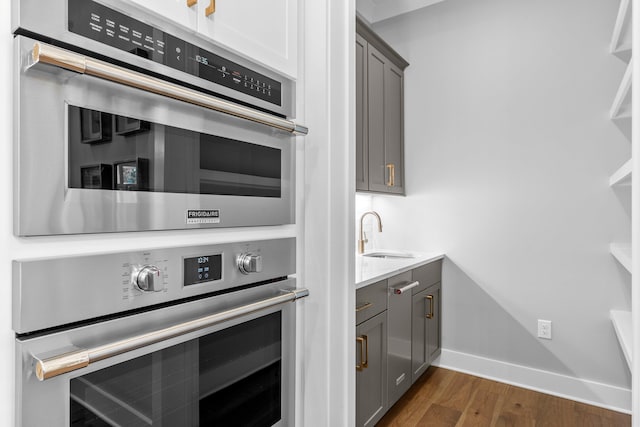 kitchen featuring gray cabinets, sink, and dark hardwood / wood-style flooring